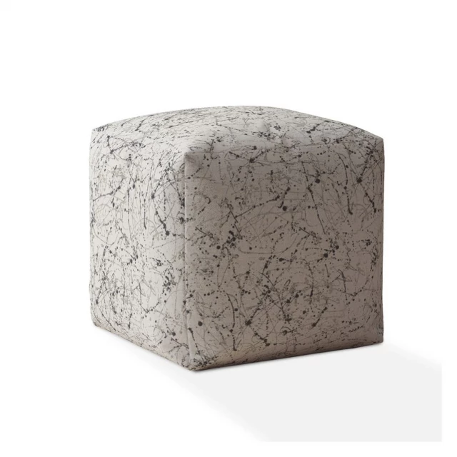 Beige flax abstract pouf cover with a textured design in a natural setting