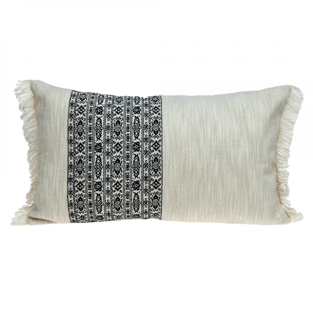 Black and white geometric patterned fringe throw pillow on couch