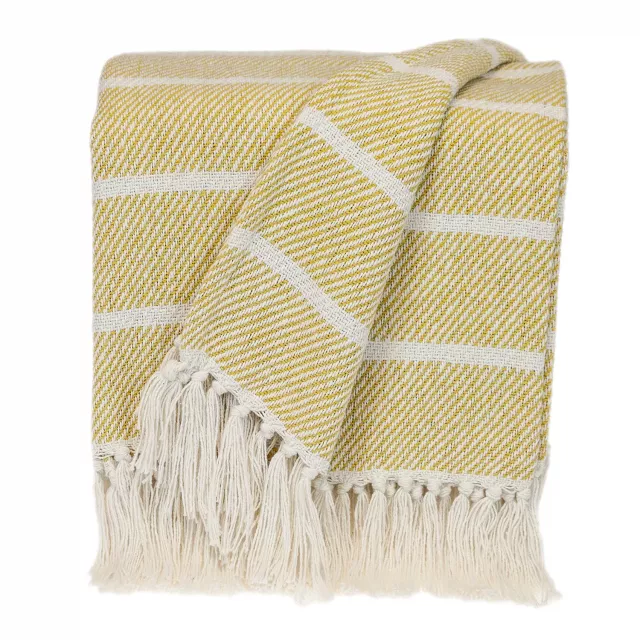 Yellow transitional striped throw displayed with patterned linens and fashion accessories