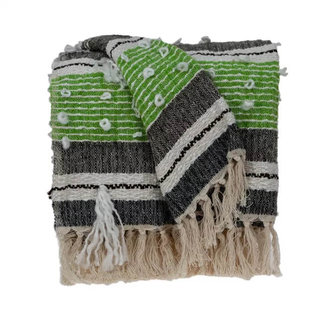 Black woven wool solid reversible throw displayed in a house setting with a brick building and grass in the background