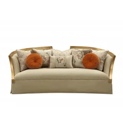 Gold upholstery sofa with wood leg trim and pillows on a comfortable studio couch.
