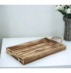 brown wooden tray with rope handles on hardwood table with flowers and plants