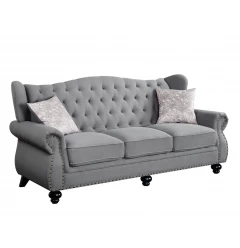 Gray black sofa with toss pillows and beige wood accents in a comfortable studio couch design