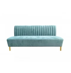 Stylish light green fabric gold sofa with comfortable armrests and wood accents in a studio setting