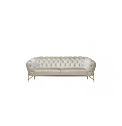 Beige tufted velvet gold chesterfield sofa in a comfortable indoor setting with wooden accents