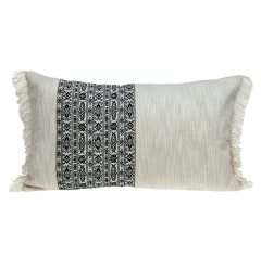 Black and white geometric patterned fringe throw pillow on couch