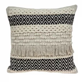 Black zippered cotton throw pillow with fringe and patterned design on chair
