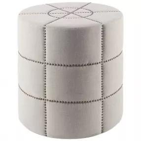 Cream linen round footstool ottoman with beige leather and metal accents in a fashion accessory style