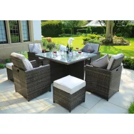 Brown square outdoor dining set with beige cushions and surrounding plants