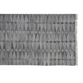 woven stain resistant area rug with fringe in grey pattern on wooden floor